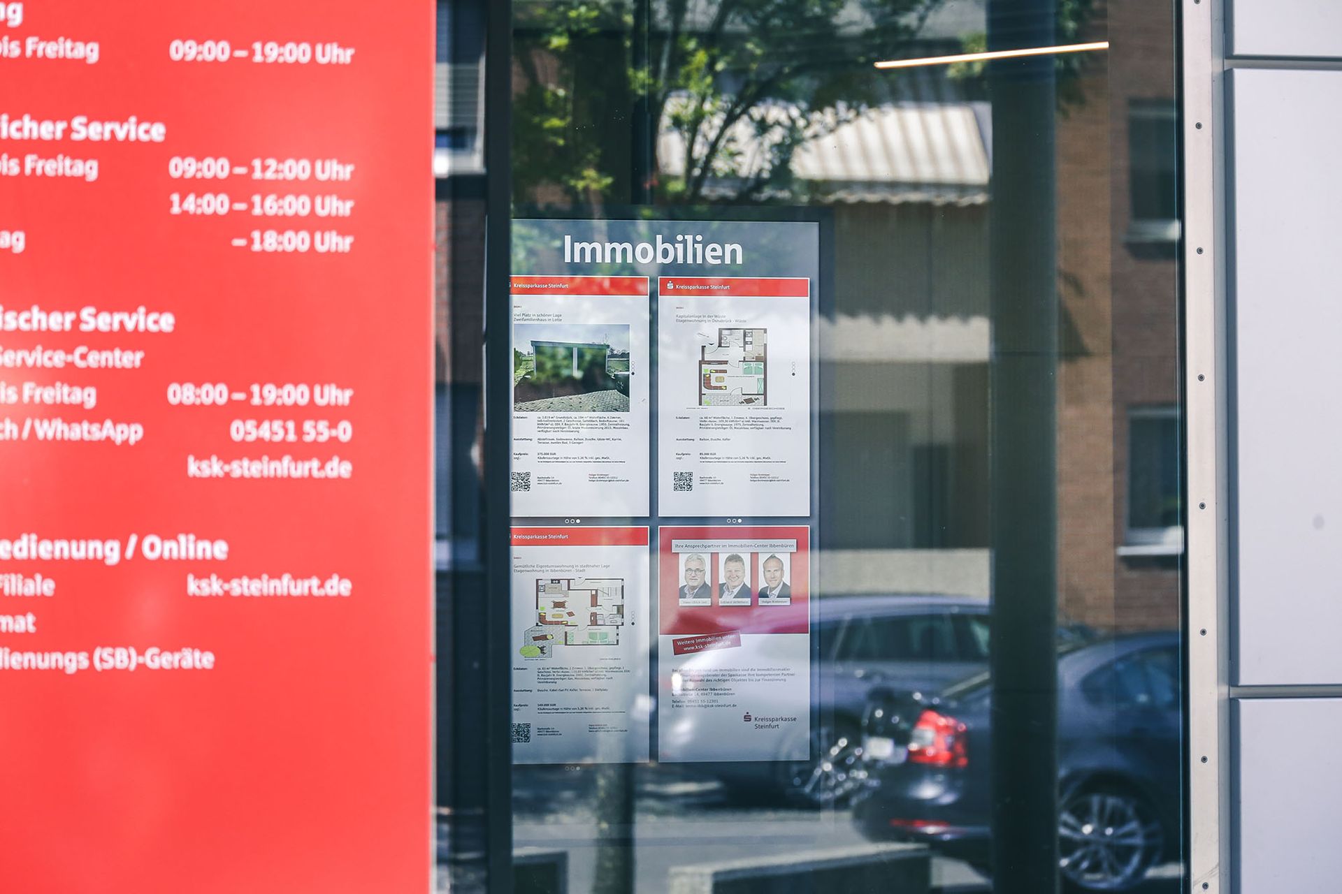 Digitale Imobilienanzeigen im Schaufenster einer Sparkasse.
