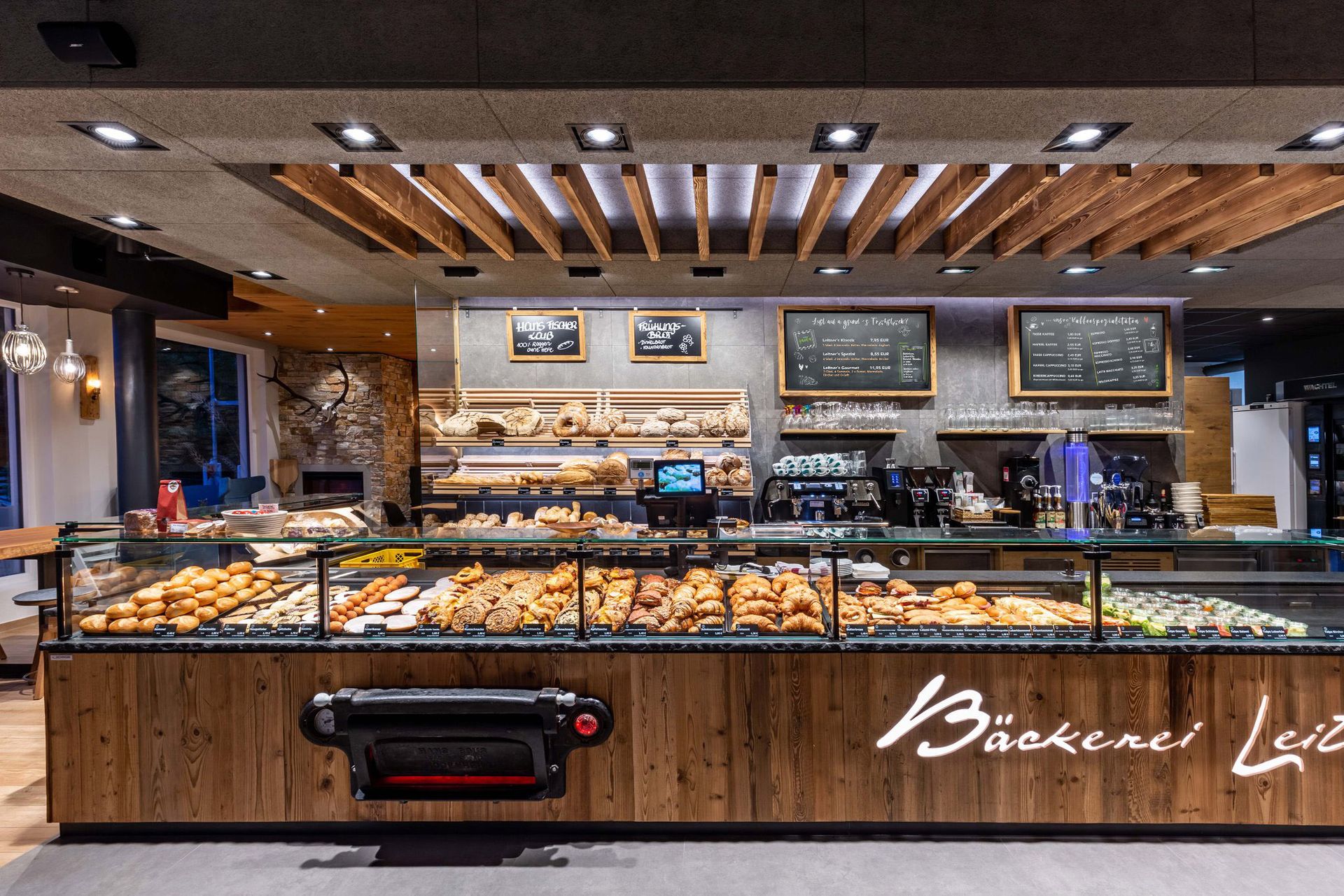 Digitale Menüboards in Holzoptik in einer Bäckerei.